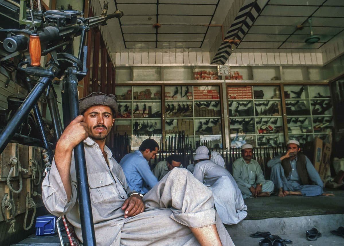 A man near the camera and several other people gathered inside a shop