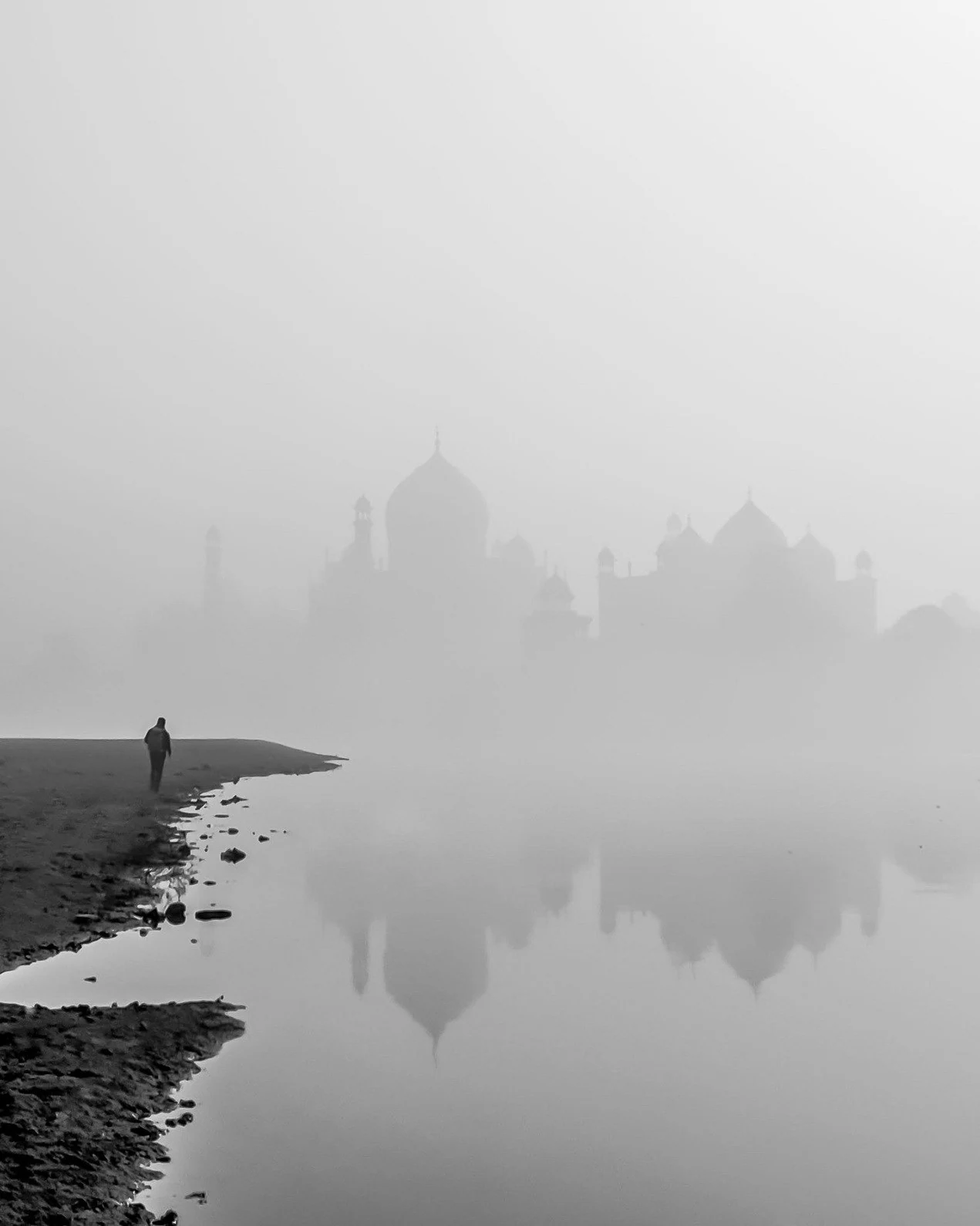 The Taj Mahal emerging through mist beside a solitary figure and reflection, photographed by Priya Ojha